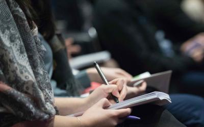 Meeting attendee taking notes.